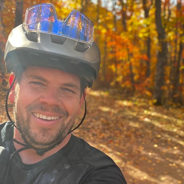 Arthur, the founder of Hey, on a mountain-bike trail in fall colors